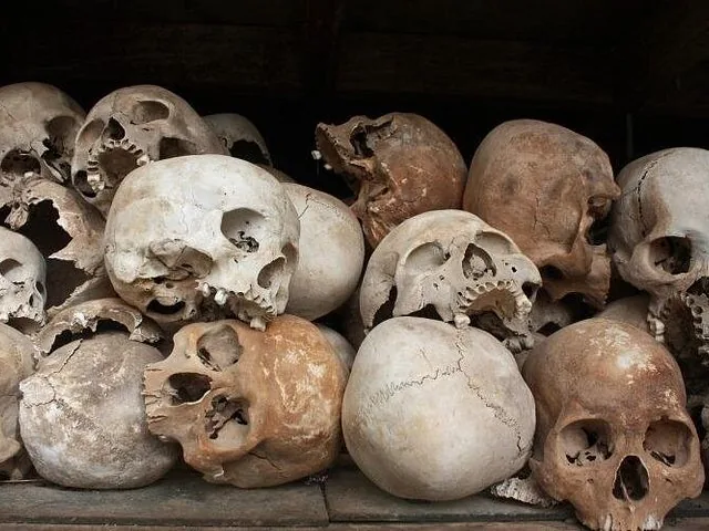 A close-up view of numerous human skulls and bones piled together.