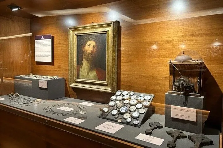 A museum display case showing a painting of Jesus and various historical artifacts.